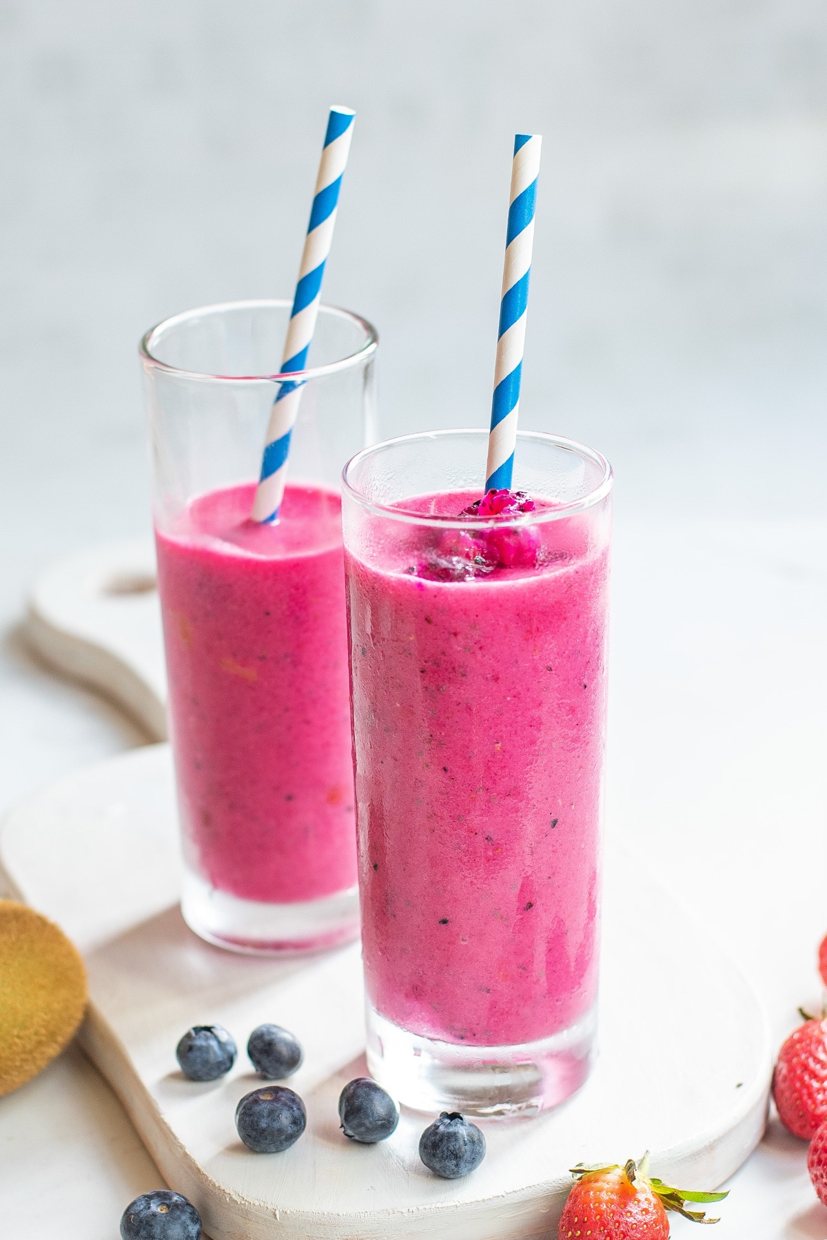 dragon fruit smoothies in glasses with straws.