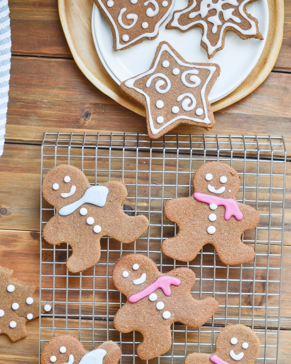 Decorated gingerbread cookies on cooling rack and plate.