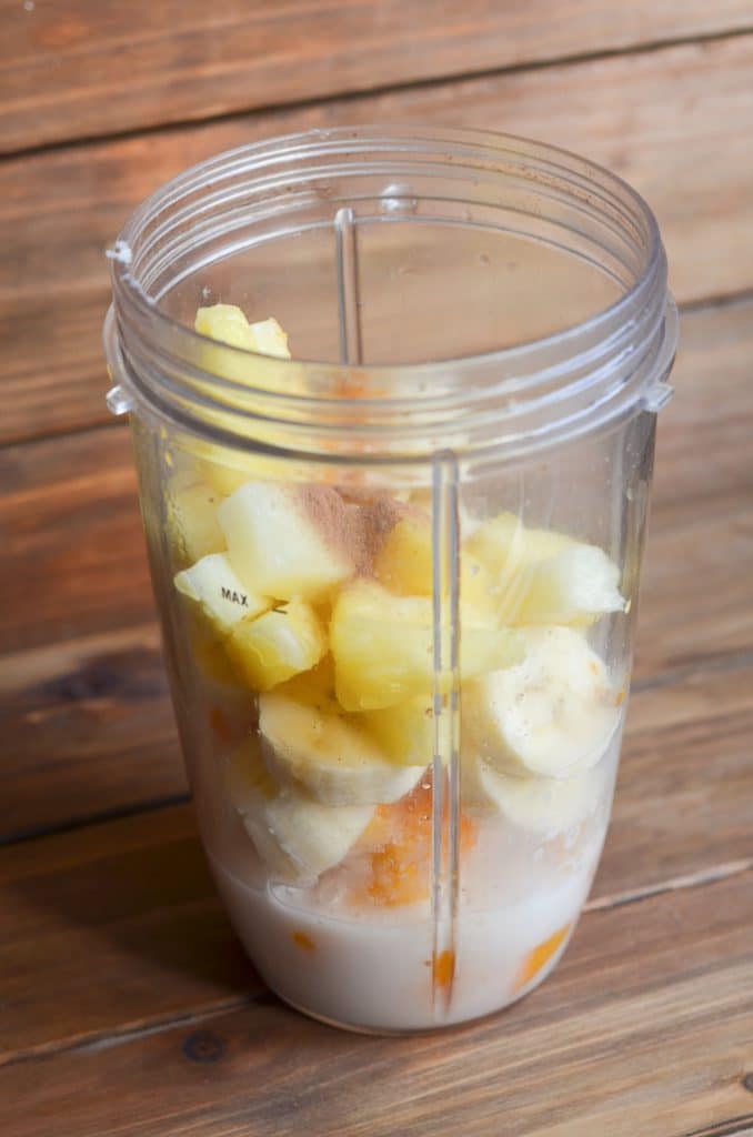 Turmeric smoothie ingredients in blender cup.