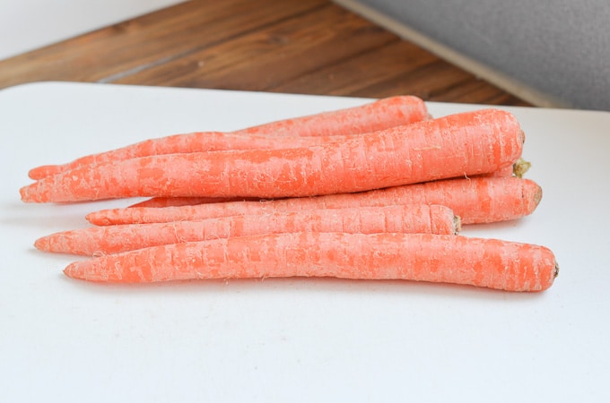 7 medium carrots on chopping board.