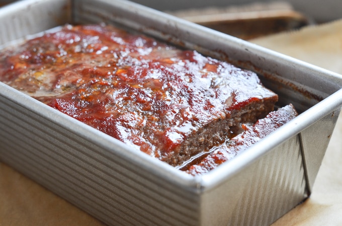 Paleo keto low carb meatloaf in loaf pan with tomato sauce.