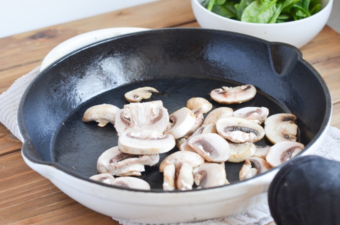 mushrooms sauteing in cast iron skillet.