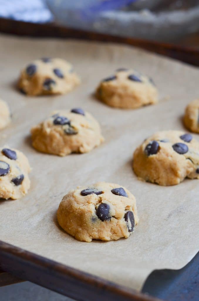 Cookies on parchment lined baking sheet ready for oven.