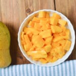 a mango and chopped mango in a bowl.