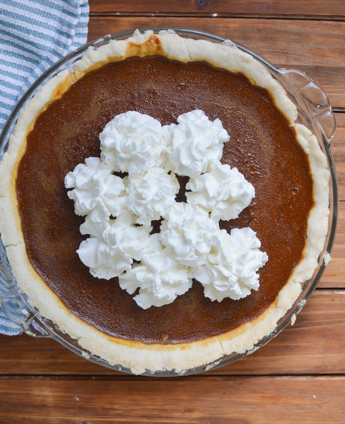 baked pumpkin pie with scoops of whipped cream.