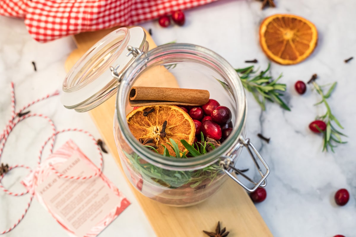 ingredients for Christmas potpourri in a glass jar.