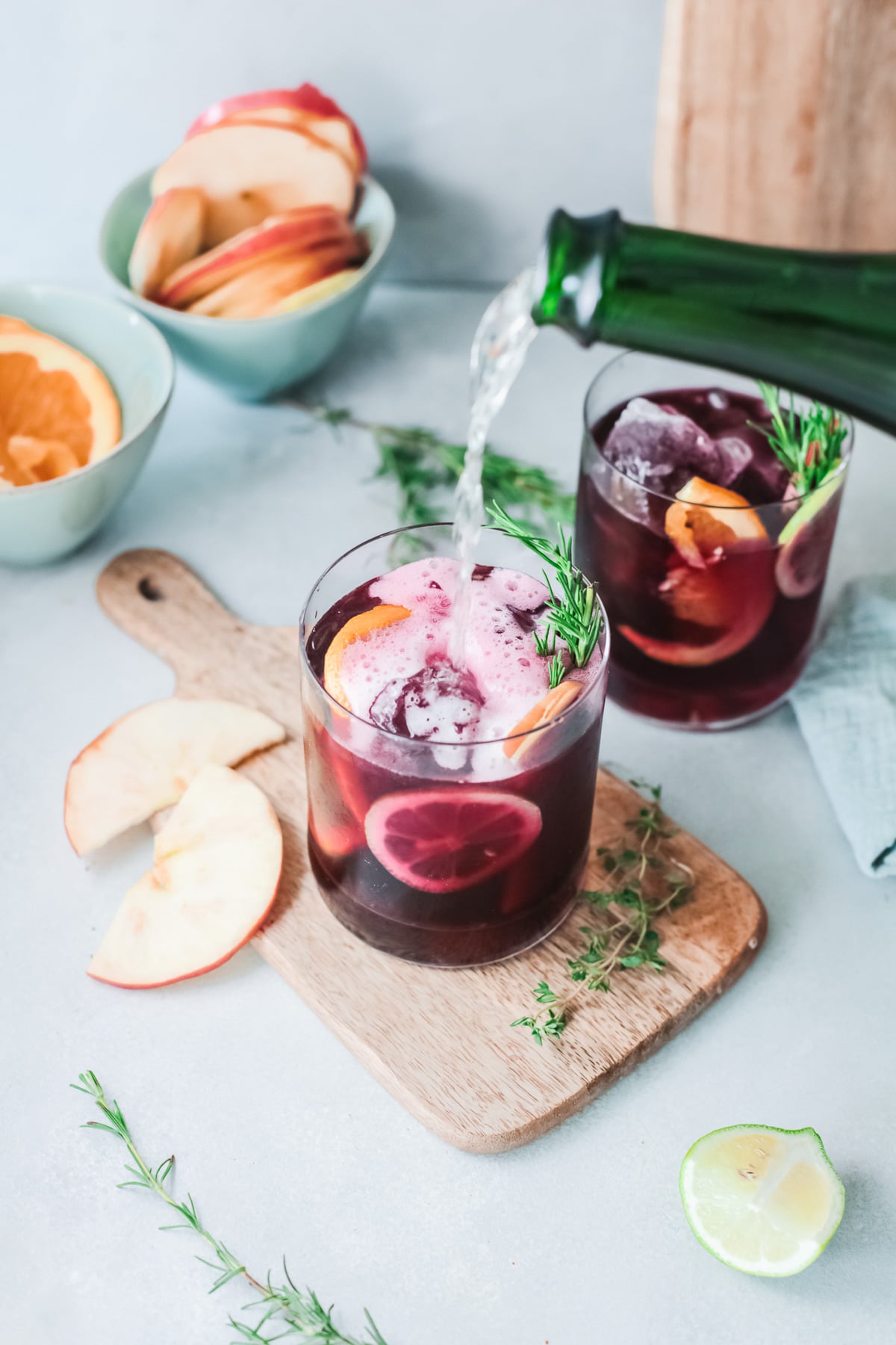 two glasses of champagne sangria with garnishes.