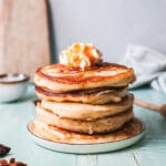 stack of eggnog pancakes with butter and syrup.