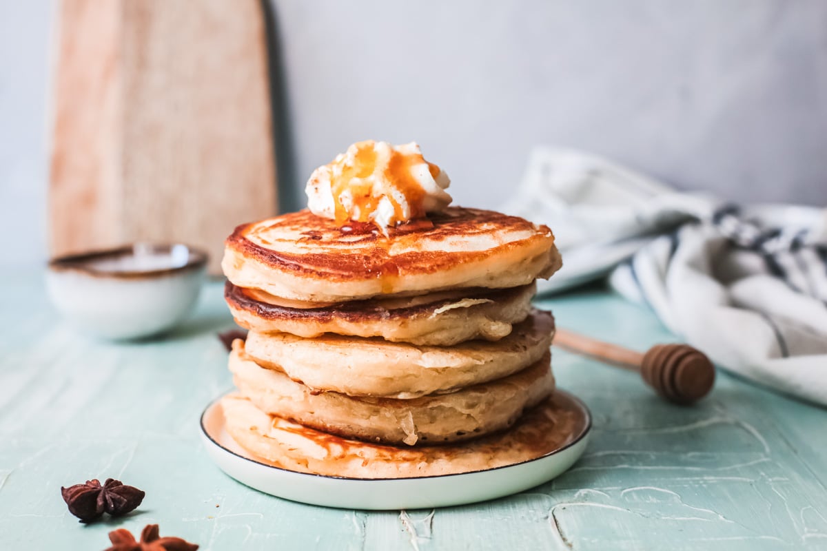 Eggnog pancakes on a plate with butter.