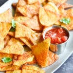 Tortilla chips on a platter with salsa.