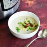 cauliflower soup in bowl next to instant pot.
