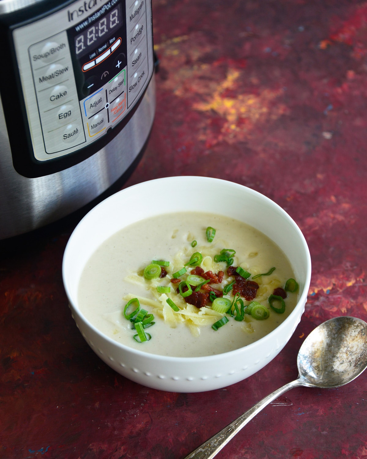 bowl of cauliflower soup next to instant pot.